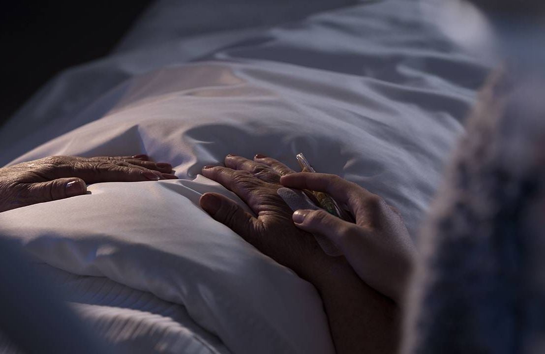 A hospice patient holding hand with a loved one. Next Avenue, hospice care