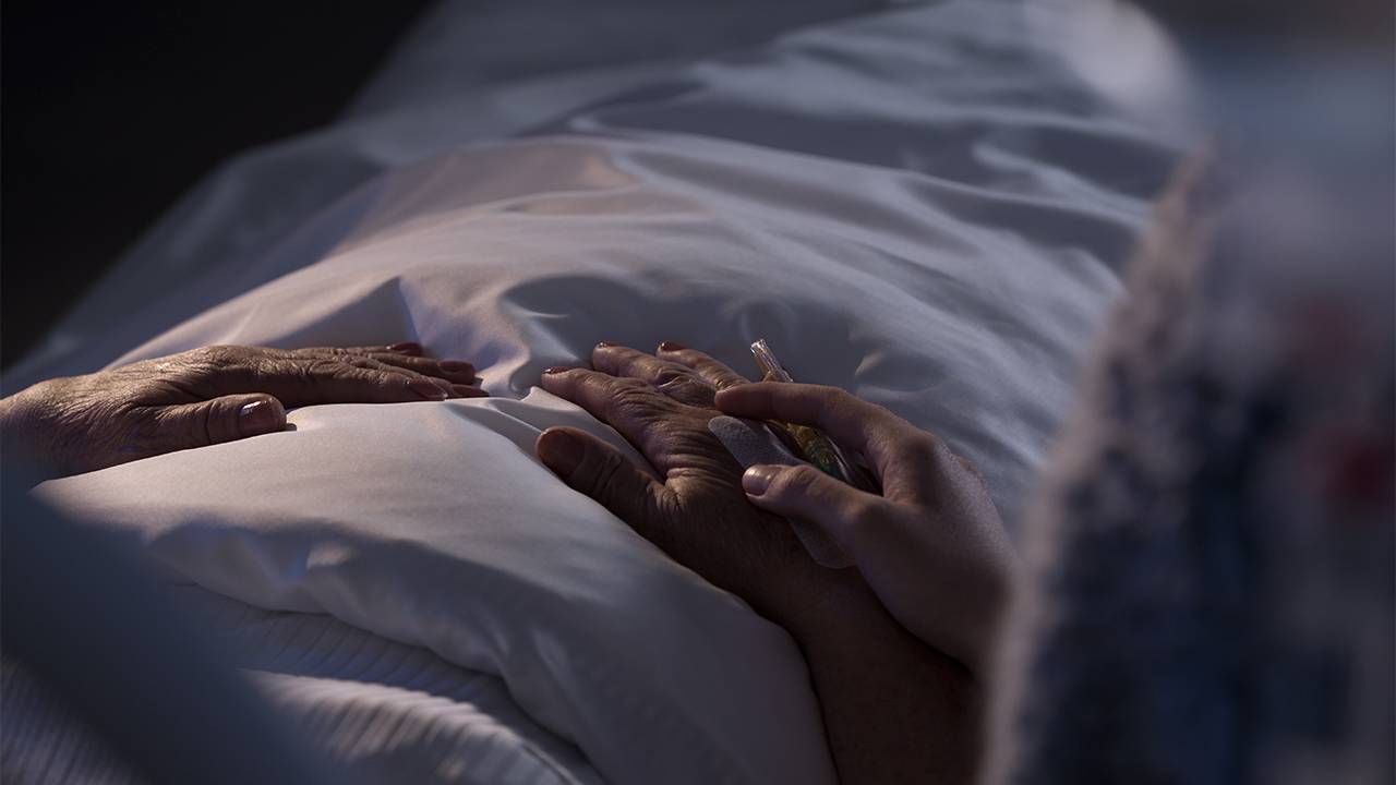 A hospice patient holding hand with a loved one. Next Avenue, hospice care