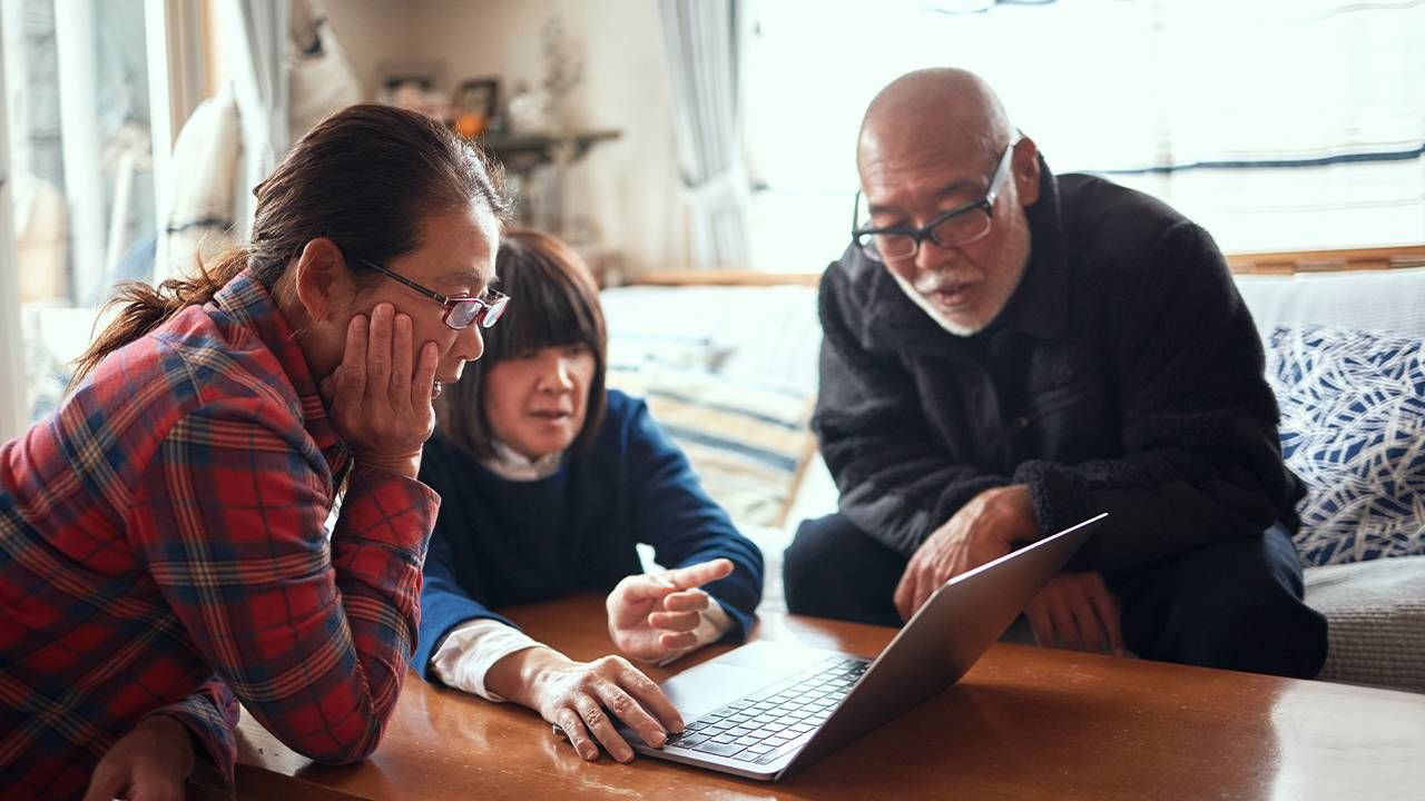 A group of friends talking and looking at computer. Investment club, Next Avenue