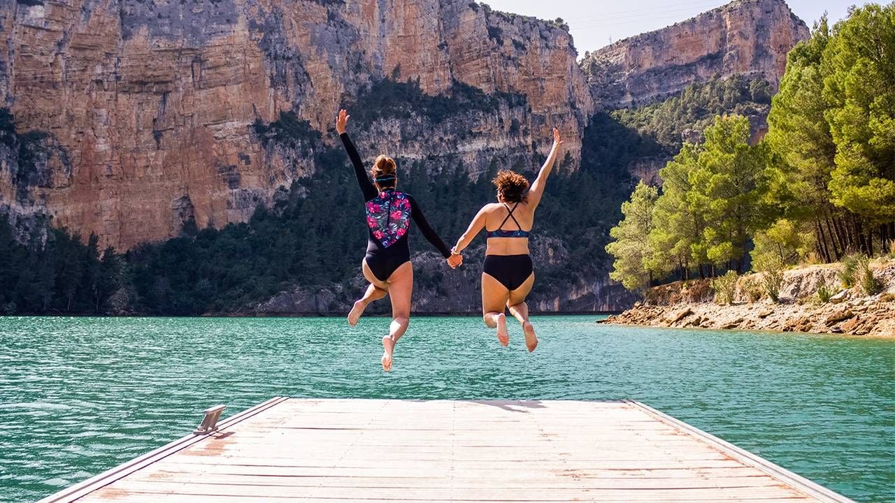 Two friends jumping off the end of a dock. Next Avenue, take a leap