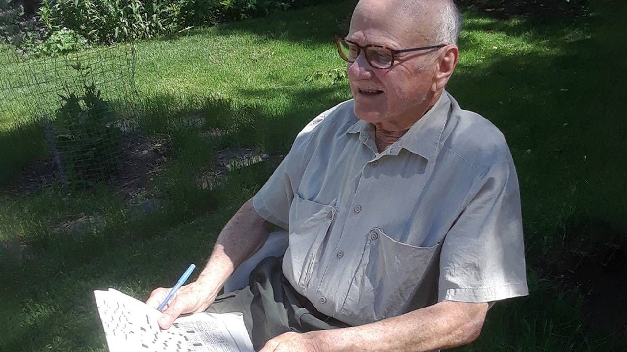 David Koulack sitting outside with a newspaper. Mild cognitive impairment, Next Avenue