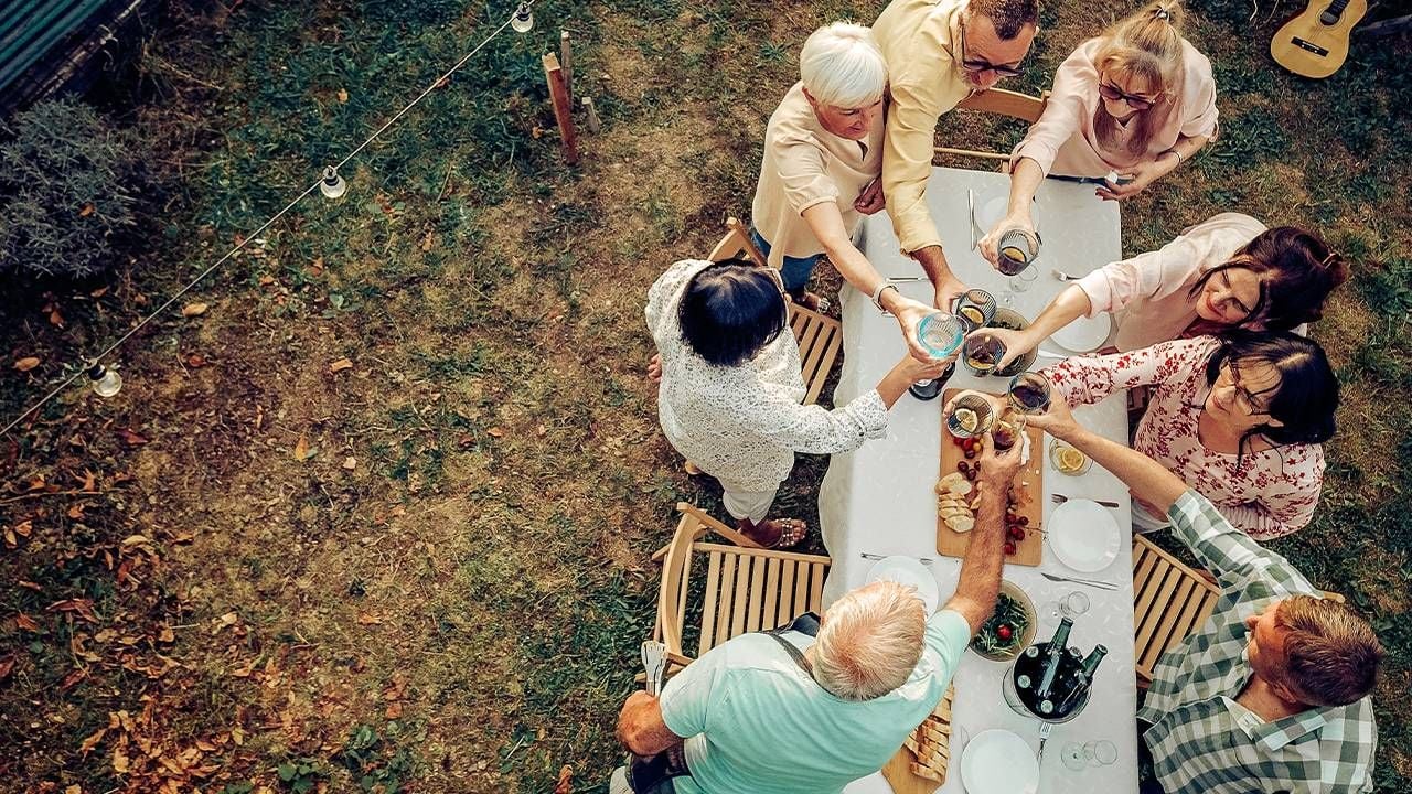 Aerial view of a group of friends eating a meal outside. Next Avenue, well-being, new normal
