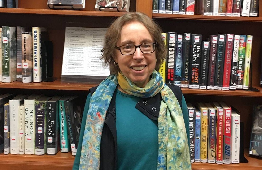 The author standing in front of a bookshelf at the library. Next Avenue