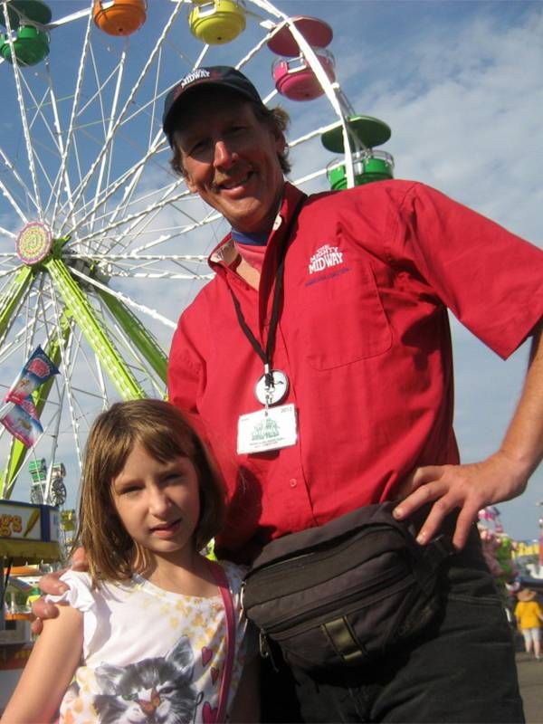 Michael Sean Comerford and his daughter at a state fair. Next Avenue, route 66, carnival