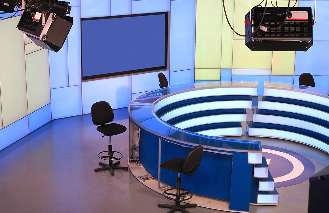 A TV news studio with empty anchor chairs. Next Avenue, Black women, cable news
