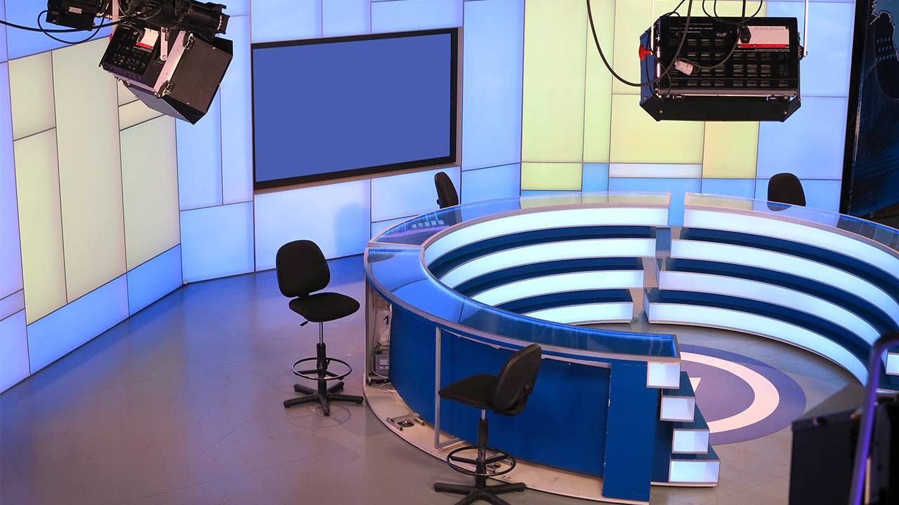 A TV news studio with empty anchor chairs. Next Avenue, Black women, cable news
