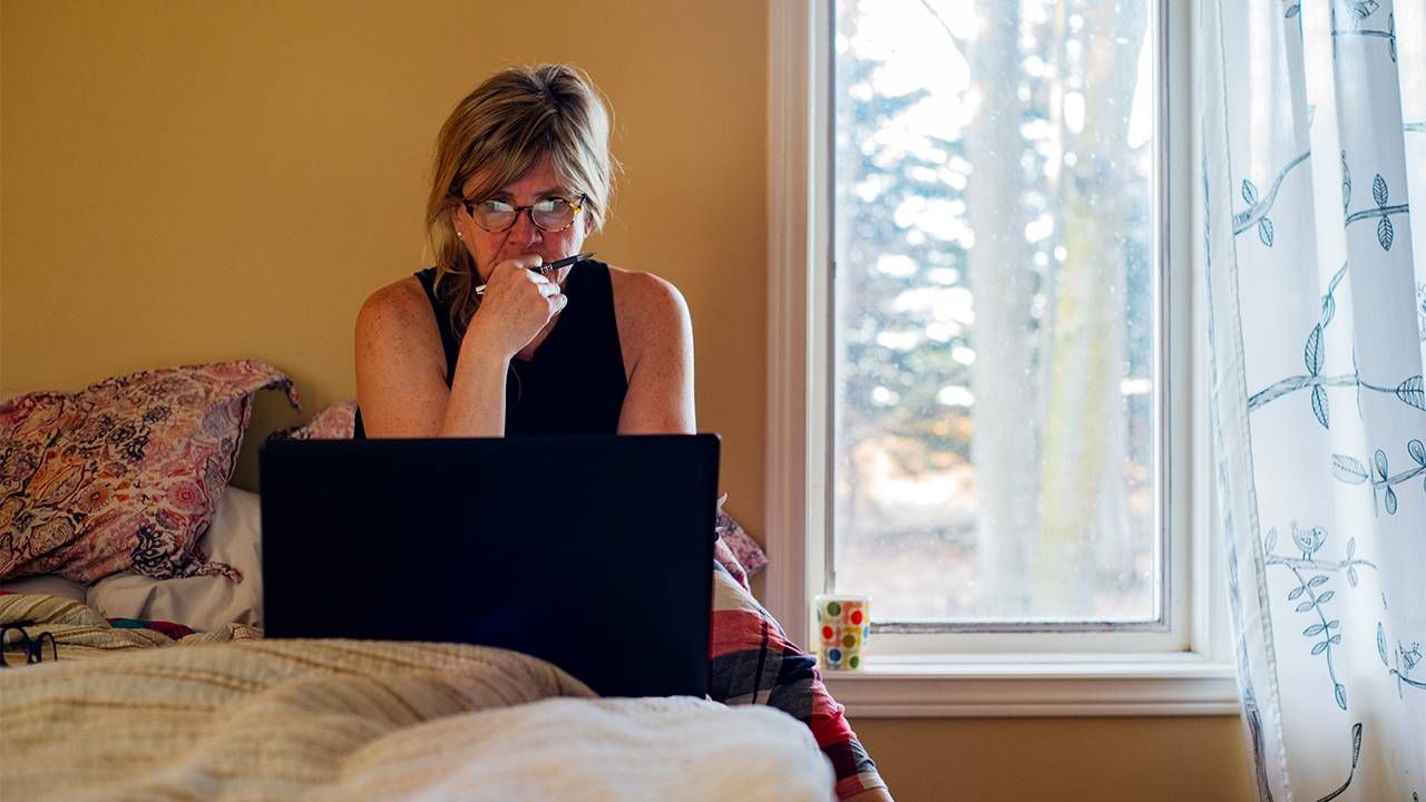 A woman checking her email. Next Avenue, email spam, spam calls, scam