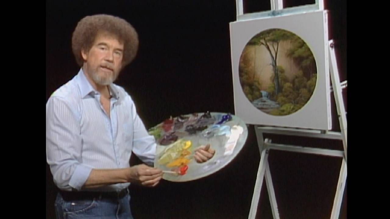 Bob Ross standing with a painter's palate and a painting. Next Avenue, Bob Ross estate, inheritance, business owners