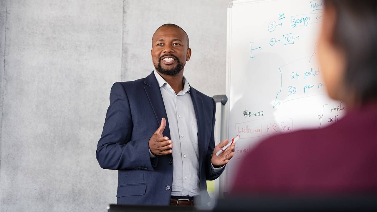 A career coach standing in front of a white board. Next Avenue, career coach, jobs, getting hired