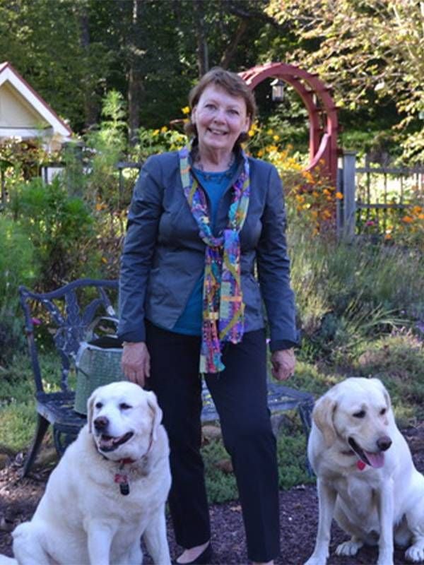 The author smiling while walking her dogs. Next Avenue, happy at work