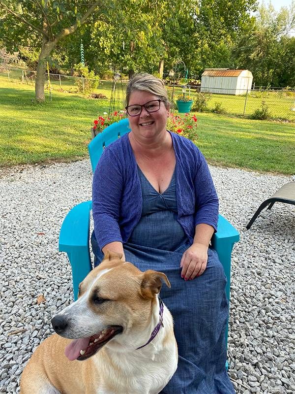 A woman sitting with her dog outside. Next Avenue, anti social dog behavior, separation anxiety, pandemic dog