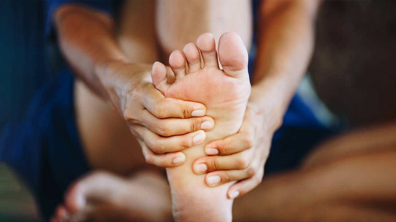 A person rubbing their foot. Next Avenue, foot pain