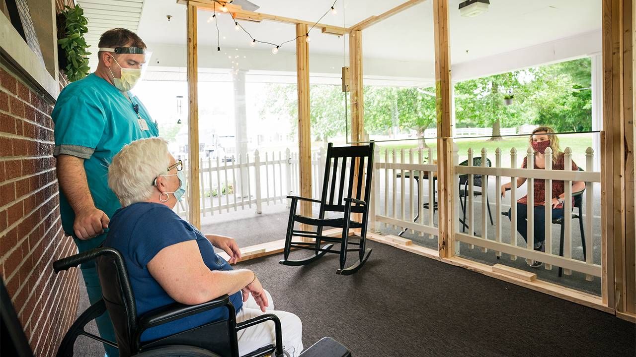 A nursing home CNA caring for a patient. Next Avenue, nursing homes infection control, COVID-19 pandemic