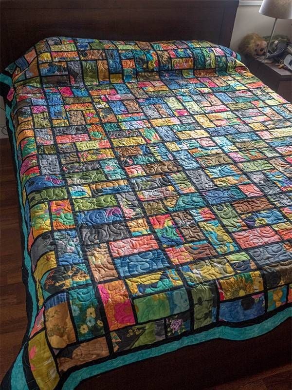 A colorful quilt on a bed. Next Avenue, vintage, repurposing, crafts