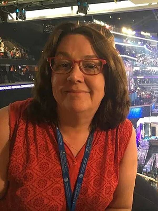 A woman in front of a crowd-filled stadium. Next Avenue, long-term unemployed, workers, AI