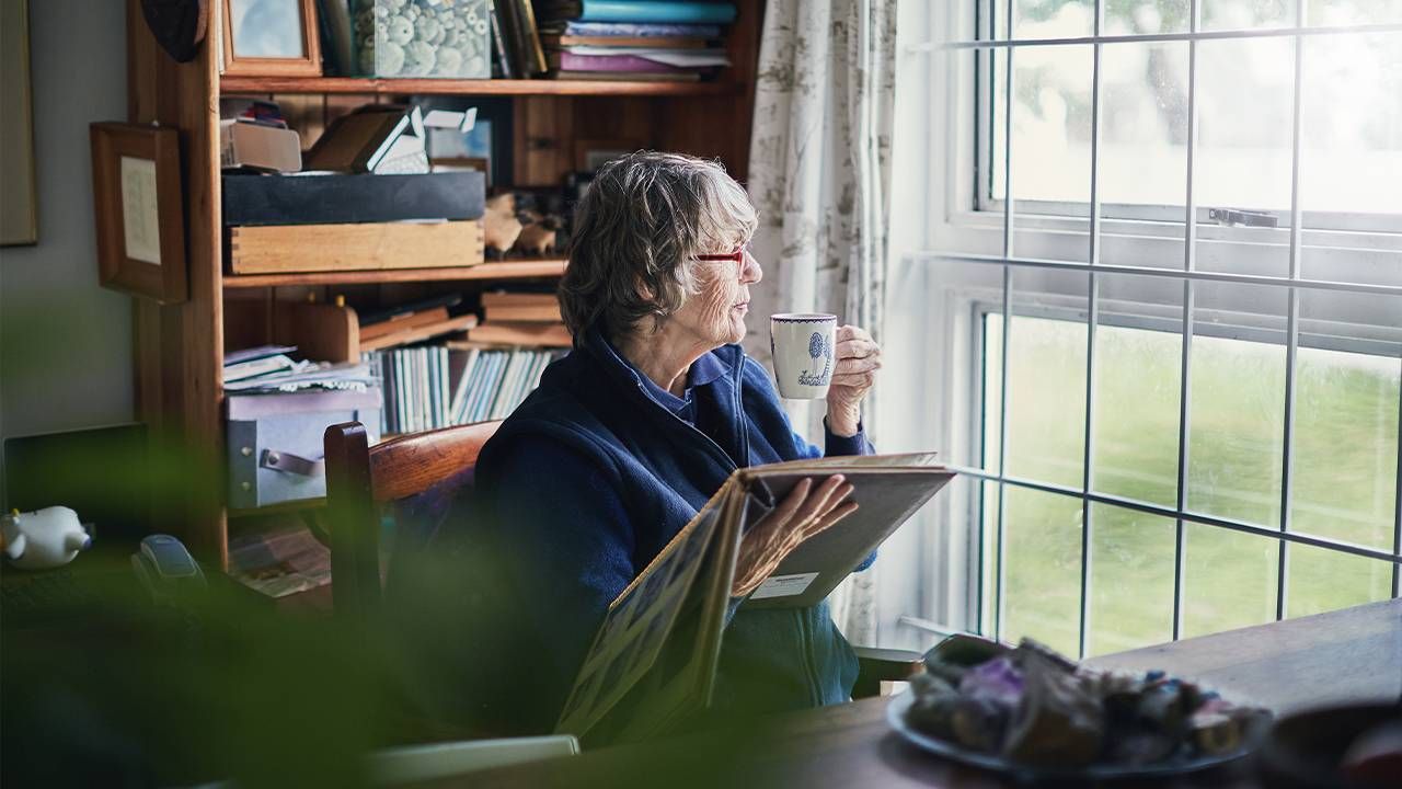 A woman alone looking out the window. Next Avenue, solo aging