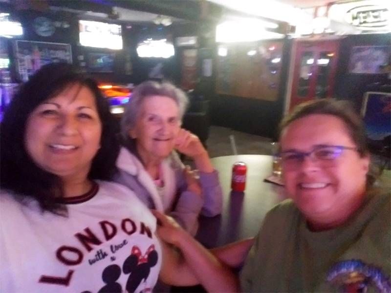 Three people sitting at a table, smiling. Next Avenue, retirement caregiving, retirees