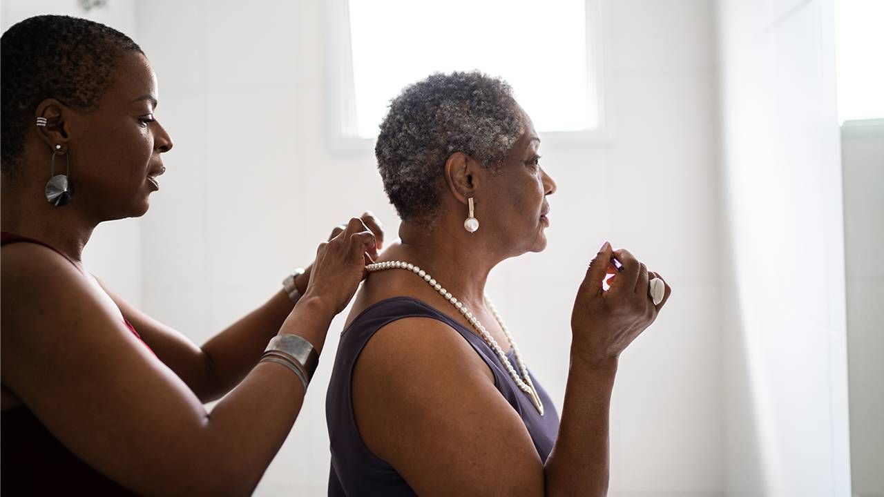 An older adult with dementia being helped by her adult daughter. Next Avenue, dementia family impacts