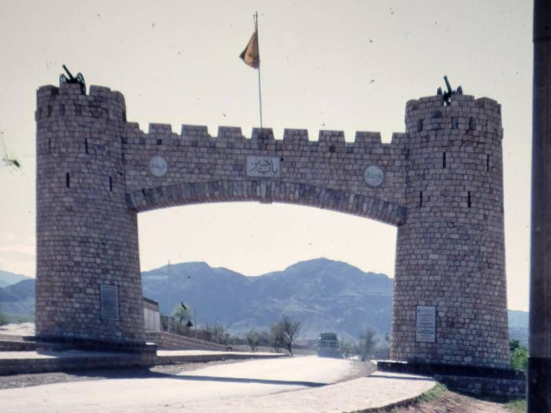 A brick castle-like overpass with a flag on top. Next Avenue, Family trip, Afghanistan, Kabul