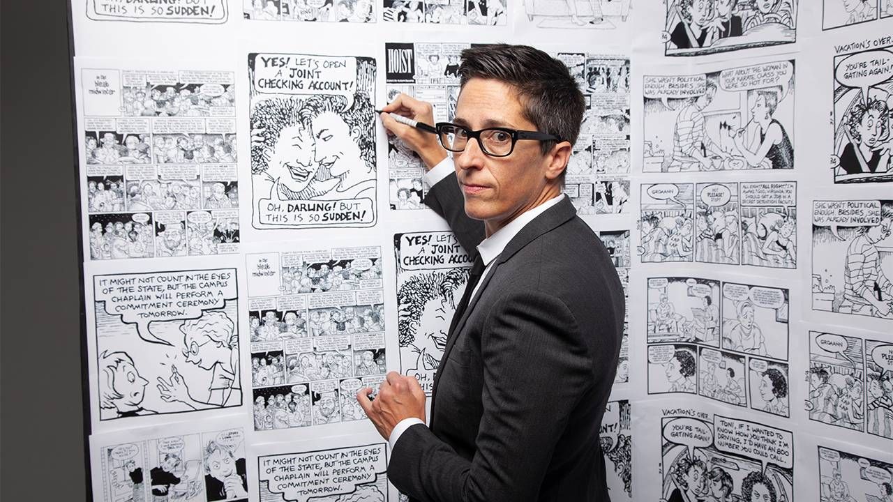 A comic artist drawing on a wall of comics. Next Avenue, queer comics, No Straight Lines