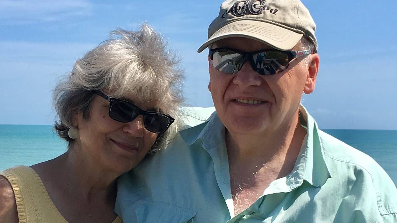 A couple smiling in front of the ocean. Next Avenue, retirement, retiring, on a budget