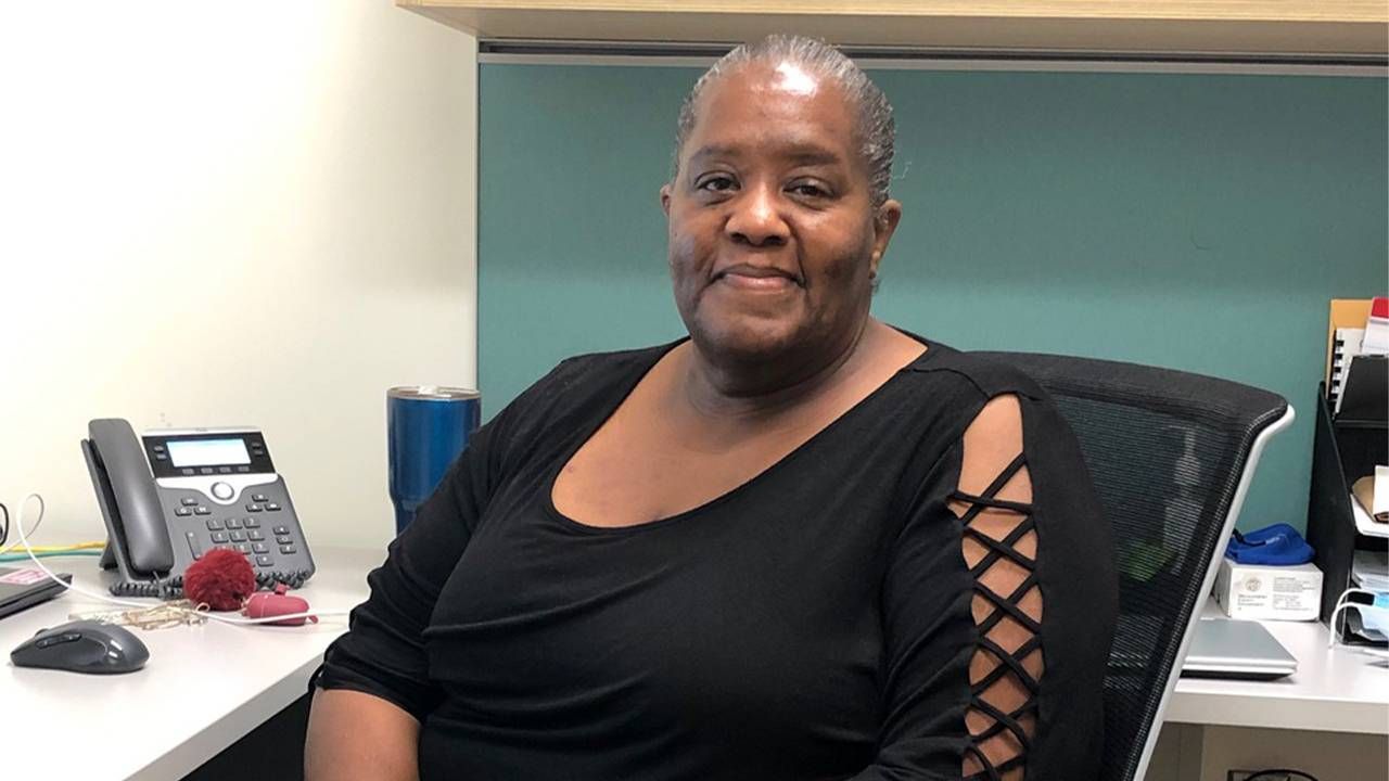 A person sitting in an office wearing a black shirt. Next Avenue, Black adults mental health, counseling