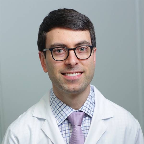 Headshot of a man wearing glasses and a doctor's lab coat. Next Avenue
