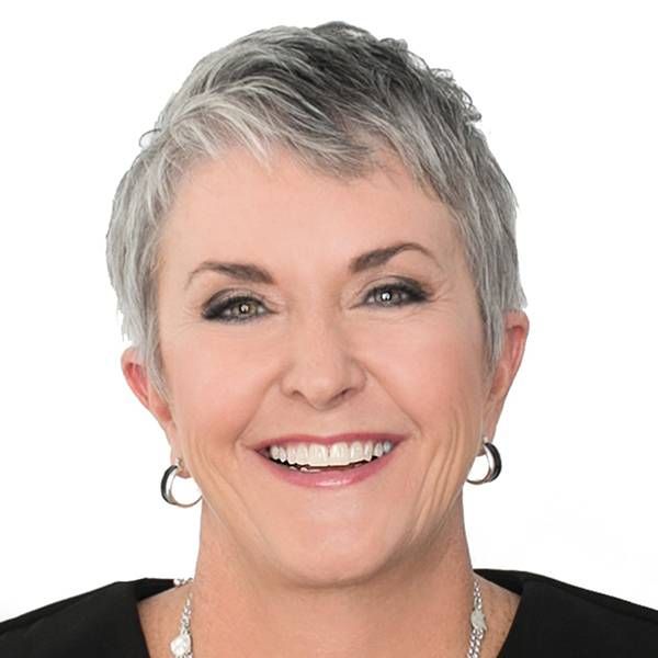 Headshot of a woman with short grey hair smiling. Next Avenue