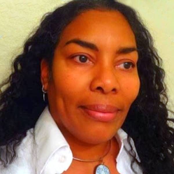 Headshot of a woman wearing a silver necklace and white shirt. Next Avenue