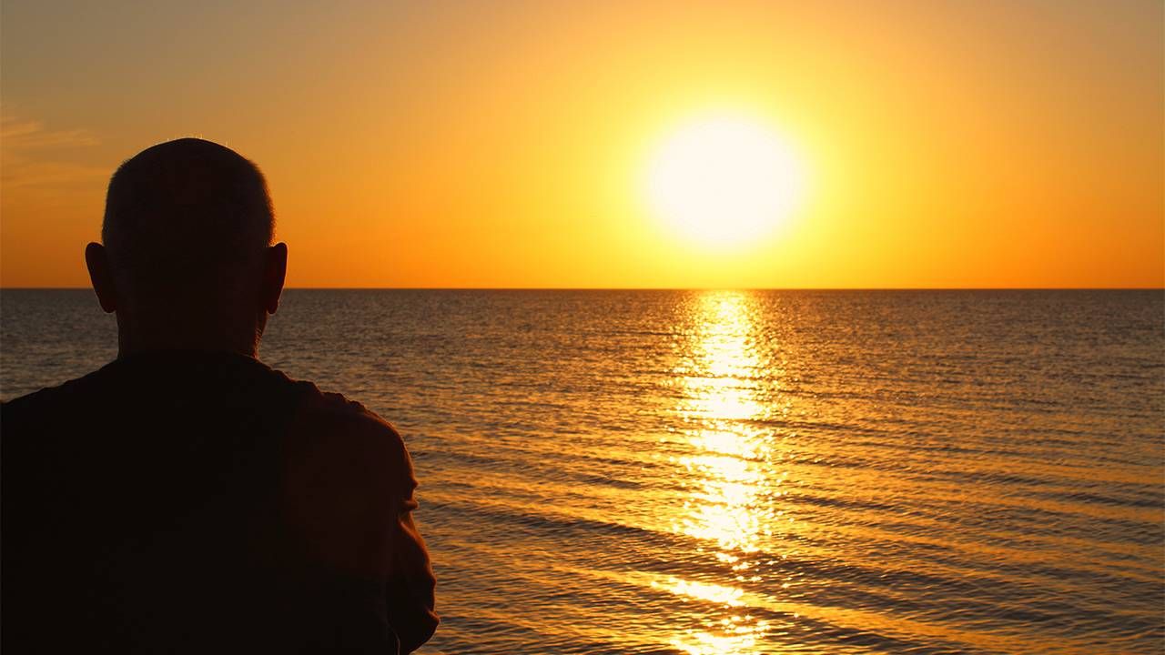 The silhouette of a person in front of a sunset. Next Avenue