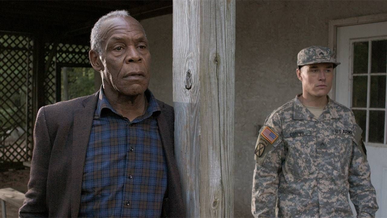 Danny Glover standing next to a veteran in The Drummer. Next Avenue