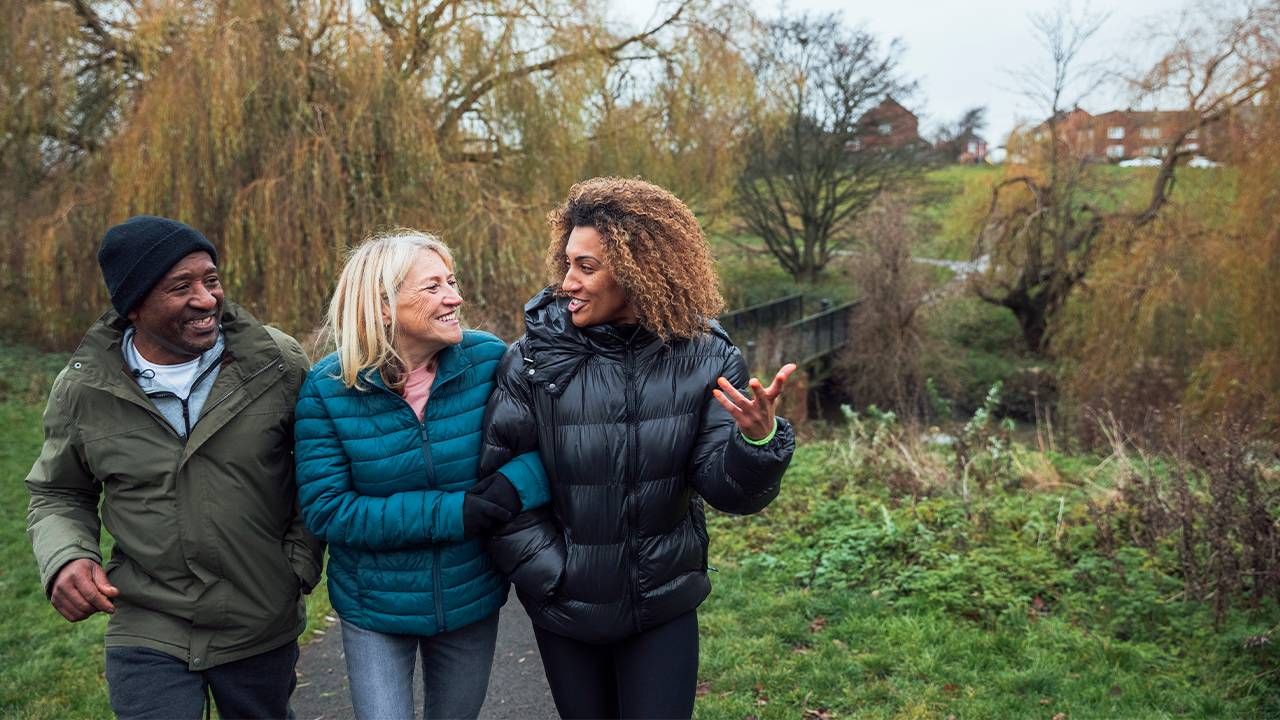 A family walking outside, working on their health, wellbeing and mental health. Next Avenue