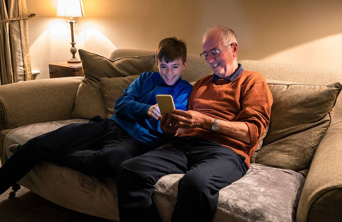 A grandparent showing his grandchild a financial gift. Next Avenue, saving
