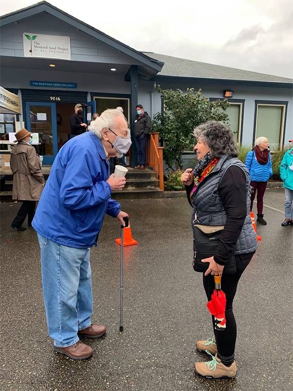 People standing outside in the rain. Next Avenue, pandemic change nursing homes