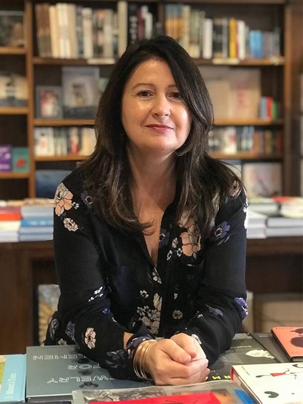 A woman smiling while standing in her bookstore. Next Avenue, celebrity memoirs