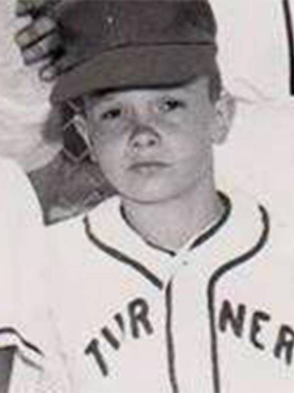 An old photo of a child wearing a black and white baseball uniform. veteran, brother, Next Avenue