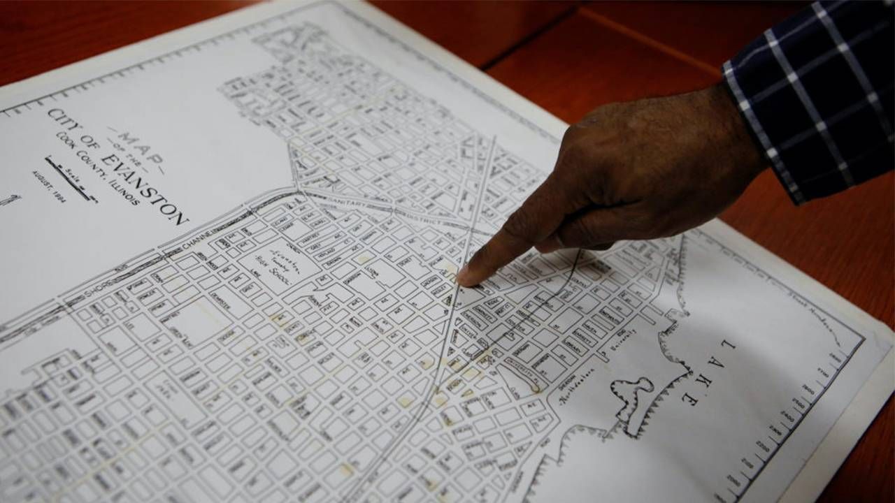 A map of Evanston, Illinois with a person's finger pointing on the map. Next Avenue, reparations, racial wealth gap