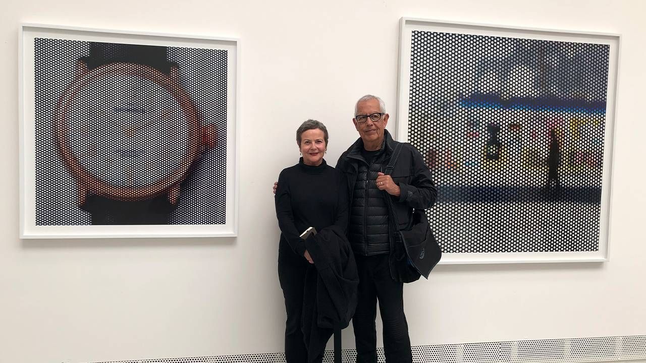 Two people wearing all black standing in front of two photographs in an art museum. Next Avenue, Judith Freeman, Anthony Hernandez