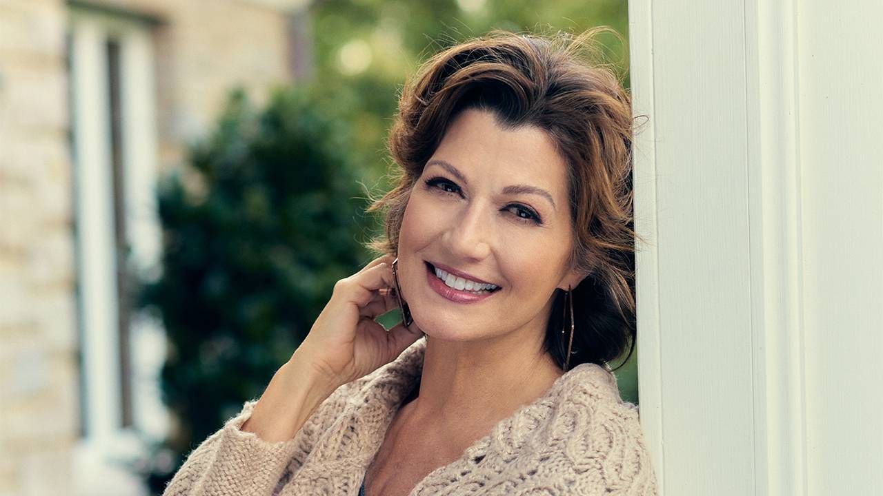 Amy Grant smiling outside standing in a pergola. Next Avenue