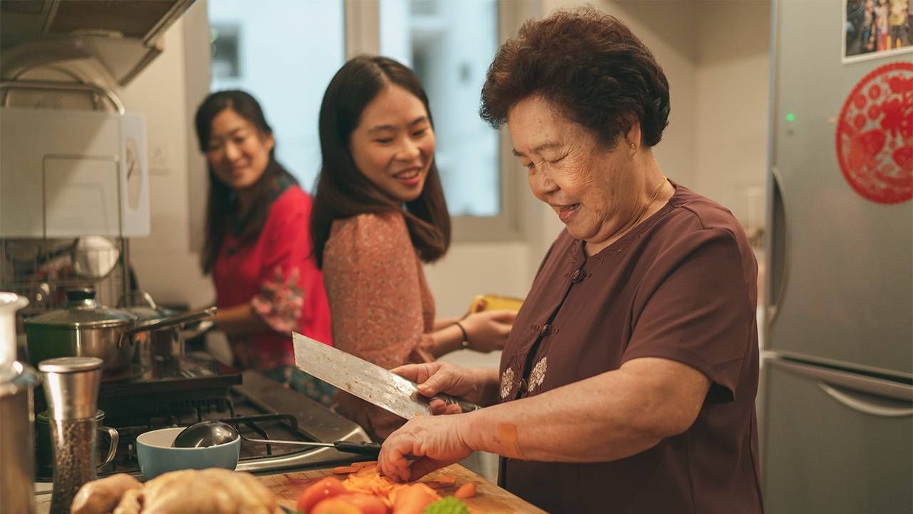 A mother and her adult children having a conversation in the kitchen about gifts. Next Avenue