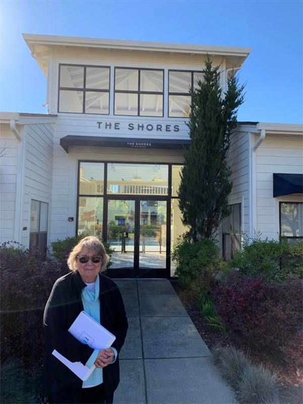 A woman standing in front of a building smiling. Next Avenue, retirement dementia