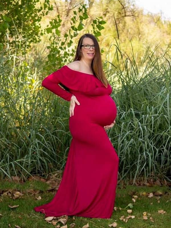 A pregnant woman wearing a red dress smiling. Next Avenue, women, clinical trials