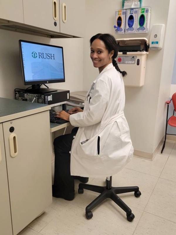 A doctor wearing a lab coat sitting at a computer. Next Avenue, bad posture