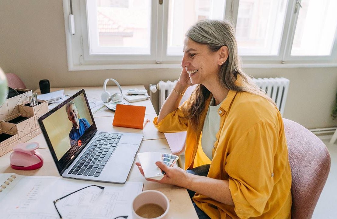 Two co-workers chatting while working from home. Next Avenue, mental health support, workplace