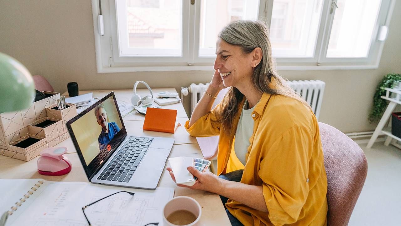 Two co-workers chatting while working from home. Next Avenue, mental health support, workplace