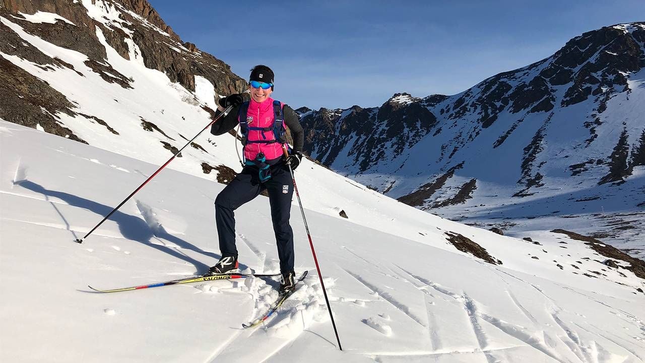 An older adult stopping after skiing on the top of a mountain. Next Avenue, skiing safely middle age