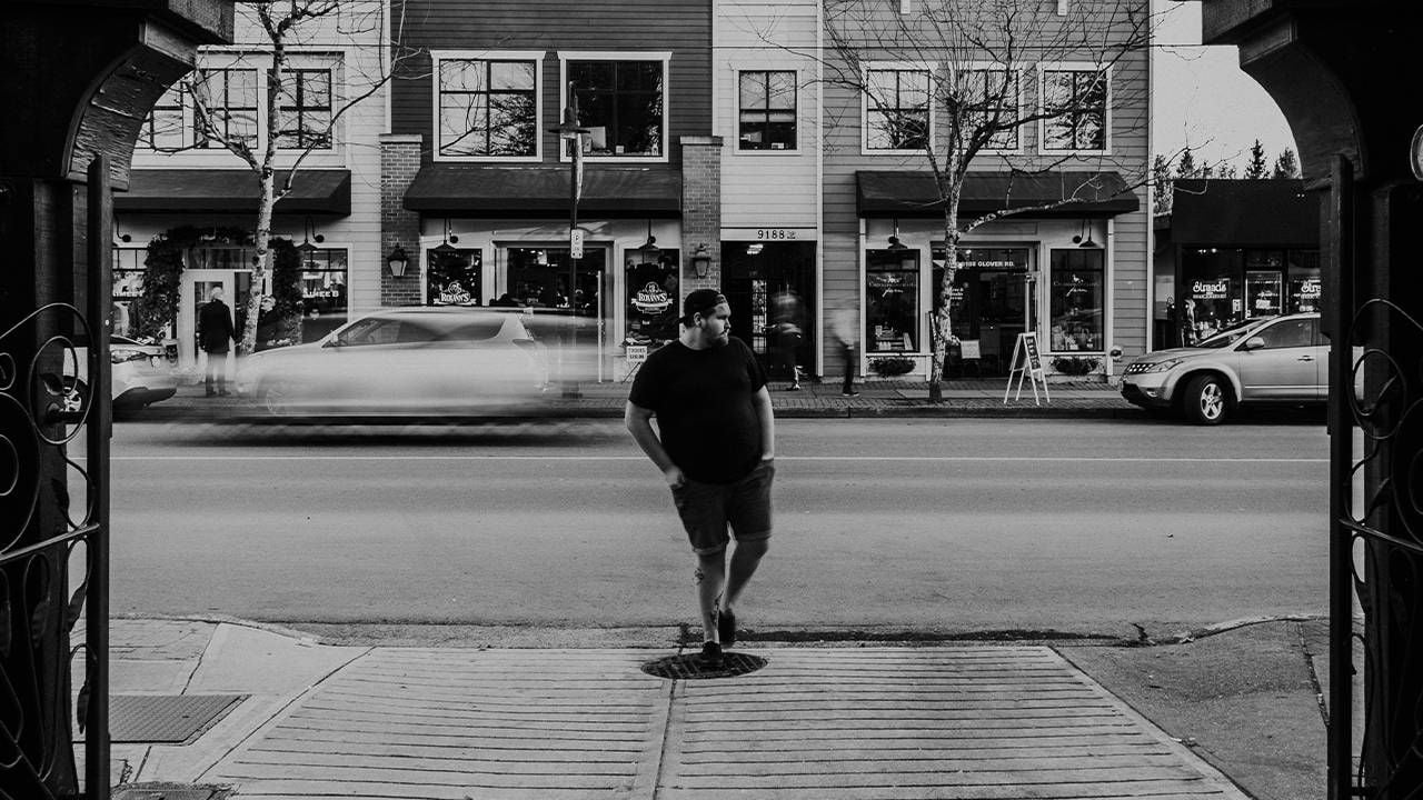 A young man standing outside of a shop on the sidewalk. Next Avenue, disability designations