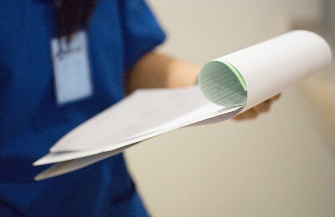 A hospital worker holding patient discharge papers. Next Avenue, patient rights