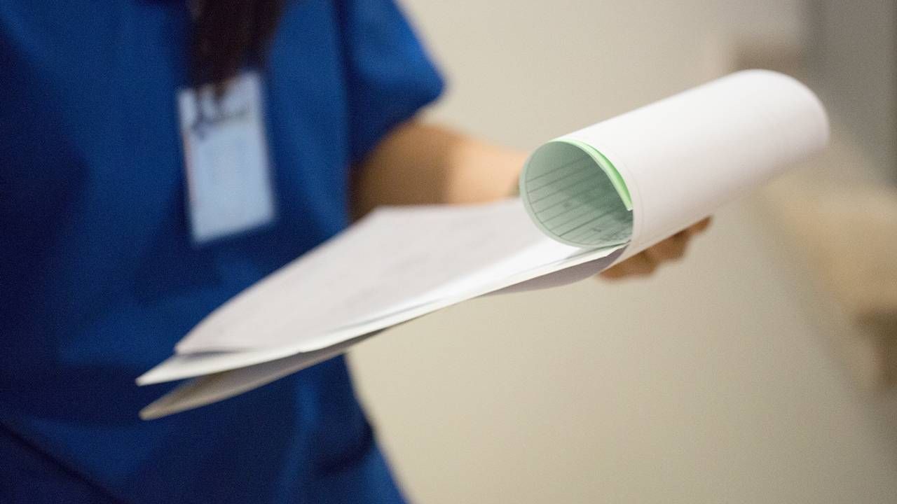 A hospital worker holding patient discharge papers. Next Avenue, patient rights