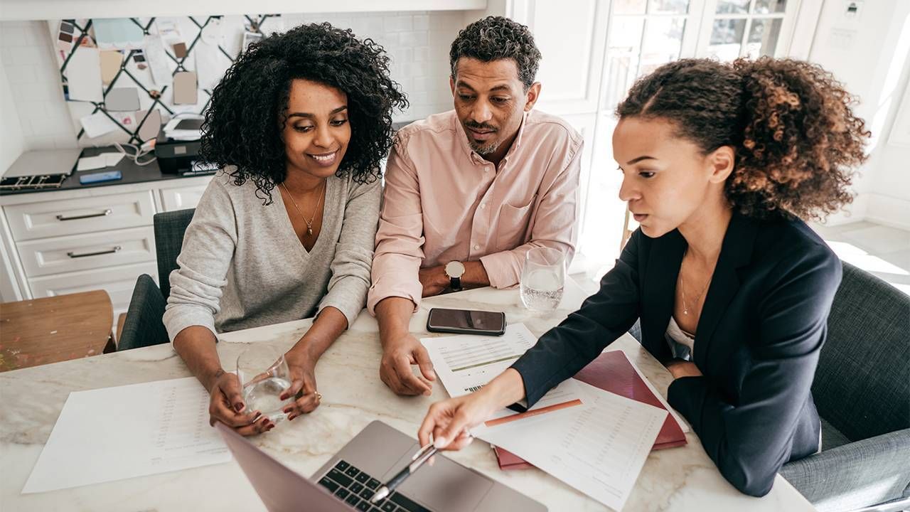 An older couple meeting with an investment advisor. Next Avenue, financial advice